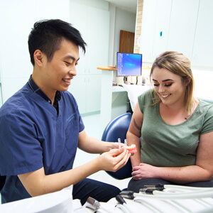 Dr Tao demonstrating invisalign braces to patient