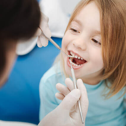 hygienist counting teeth of little girl