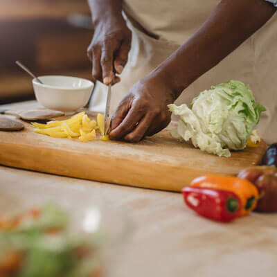 person chopping veggies on a cutting board