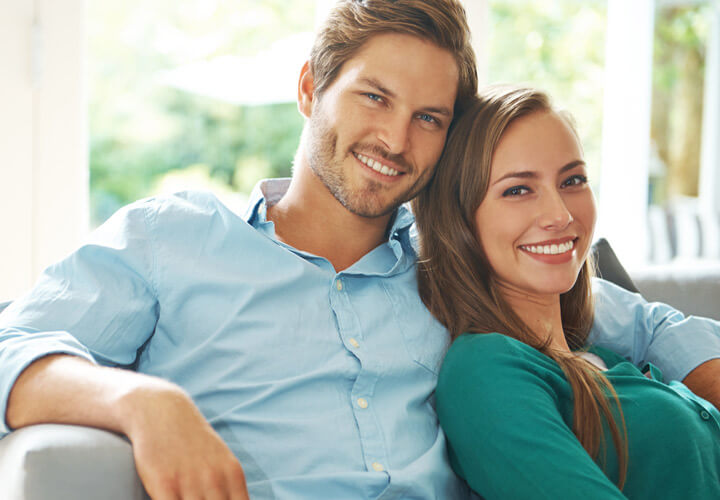 couple sitting on the couch smiling