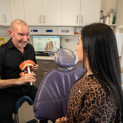 Dr Wais holding teeth model