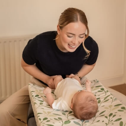 jodie smiling at baby laying on table