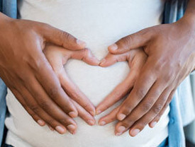 Heart hands on pregnant belly