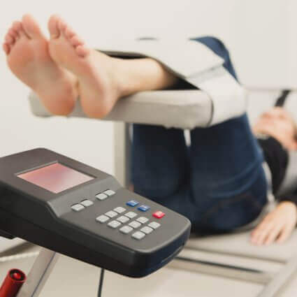 women-lying-with-feet-up-on-spinal-decompression-table-sq