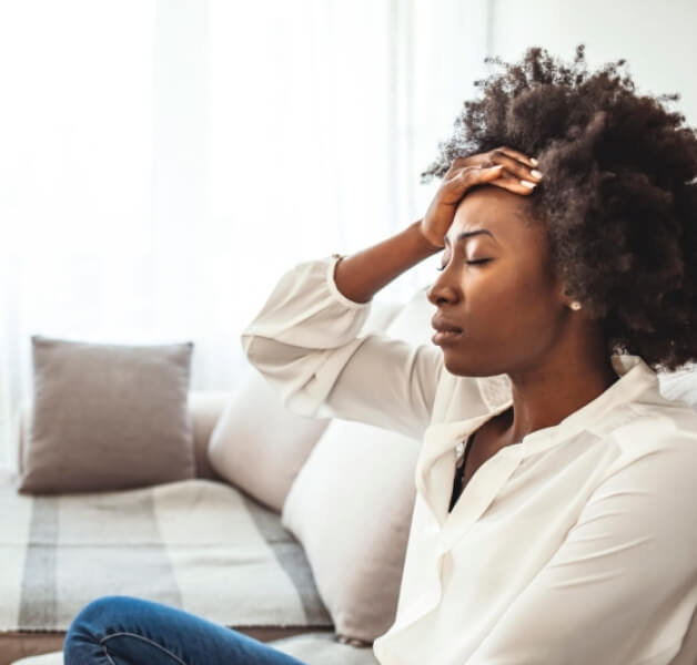 woman holding head in pain