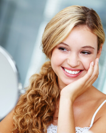 Smiling lady looking at herself in the mirror