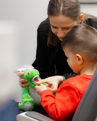 Dentist showing plush toy to child