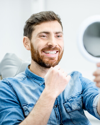 Smiling man looking at himself in the mirror