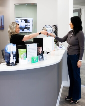 Receptionist greeting dental patient