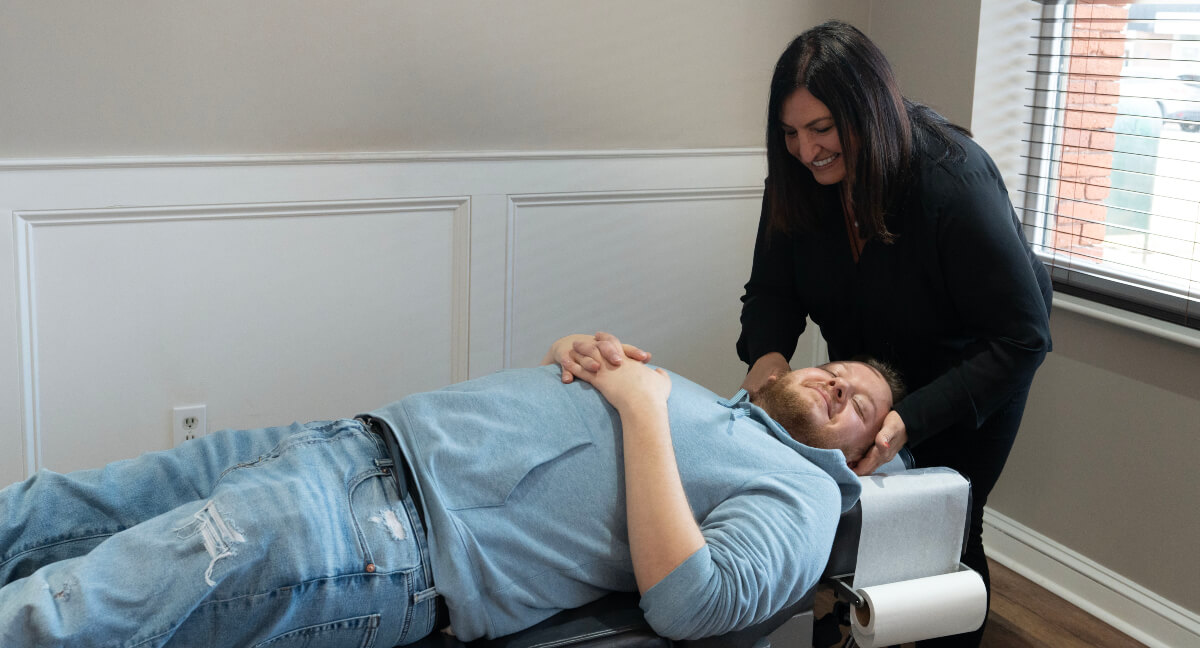 Dr. Lisa of Bazzani Chiropractic Manchester adjusting patient's neck