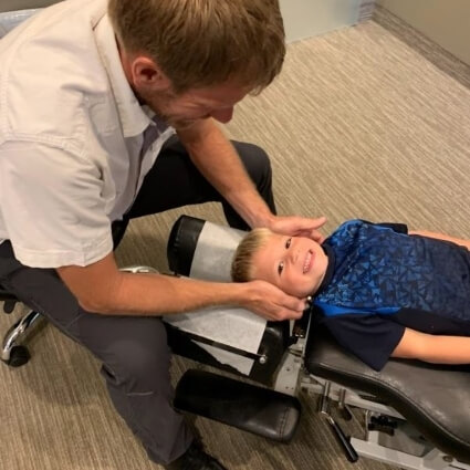 Dr J adjusting boys neck