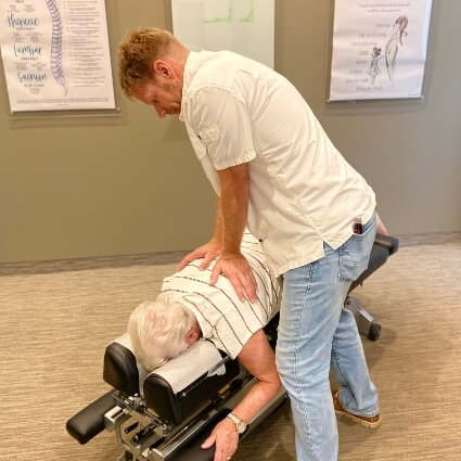 Dr J adjusting womans upper back