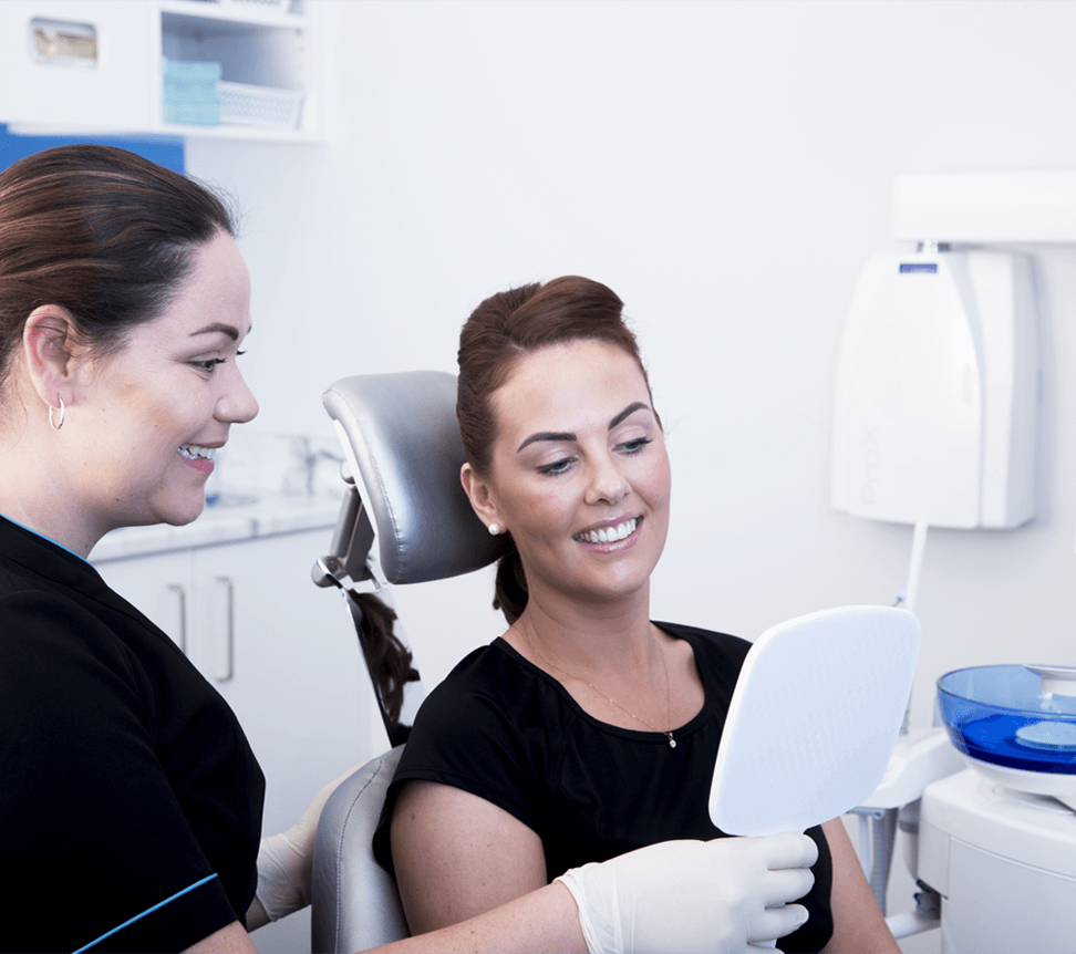 Patient looking at hand mirror