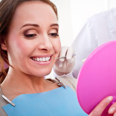 Woman looking at smile in the mirror