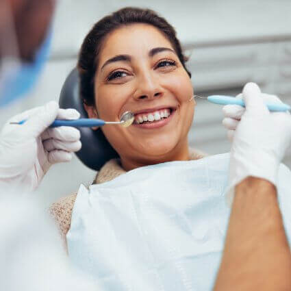 woman smiling with dental tools