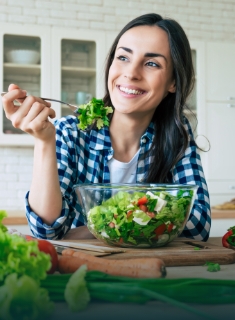Person smiling and eating a salad