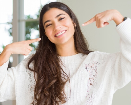 Lady pointing at her beautiful smile