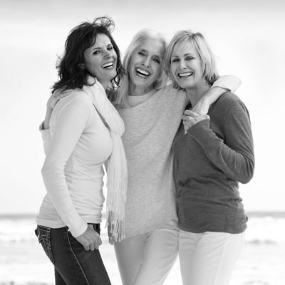 three woman smilling on beach