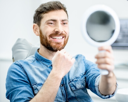 Smiling man looking at mirror