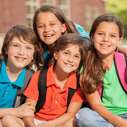 school children sitting wearing backpack