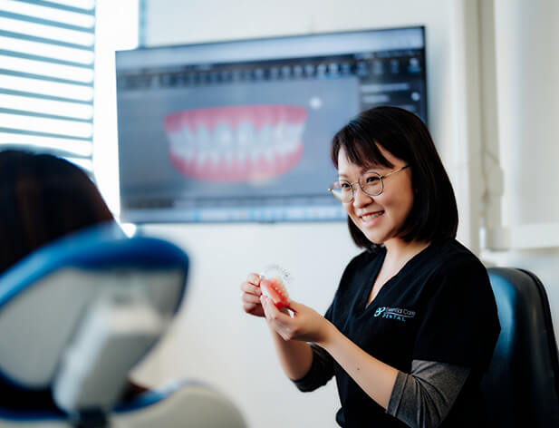 dentist showing teeth model to patient