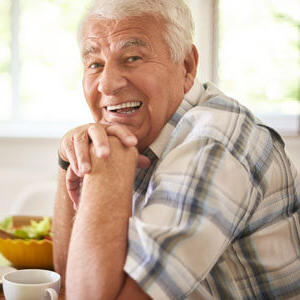 Older man with white hair sitting at table