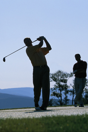 Silhouette of men golfing