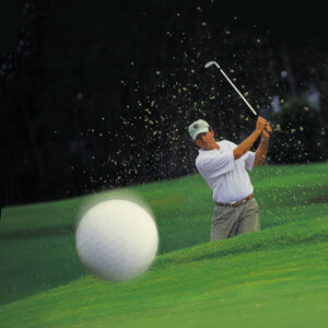 Golfer hitting golf ball