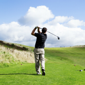 Golfer swinging at ball