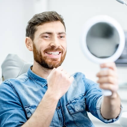 Smiling man looking at mirror