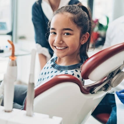 Young girl sitting in dental chair