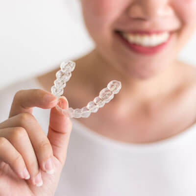 closeup of a woman holding an invisible aligner