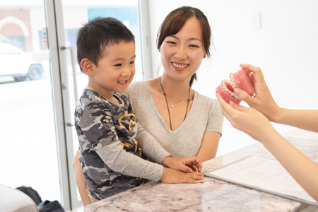 Little boy and mother at reception desk