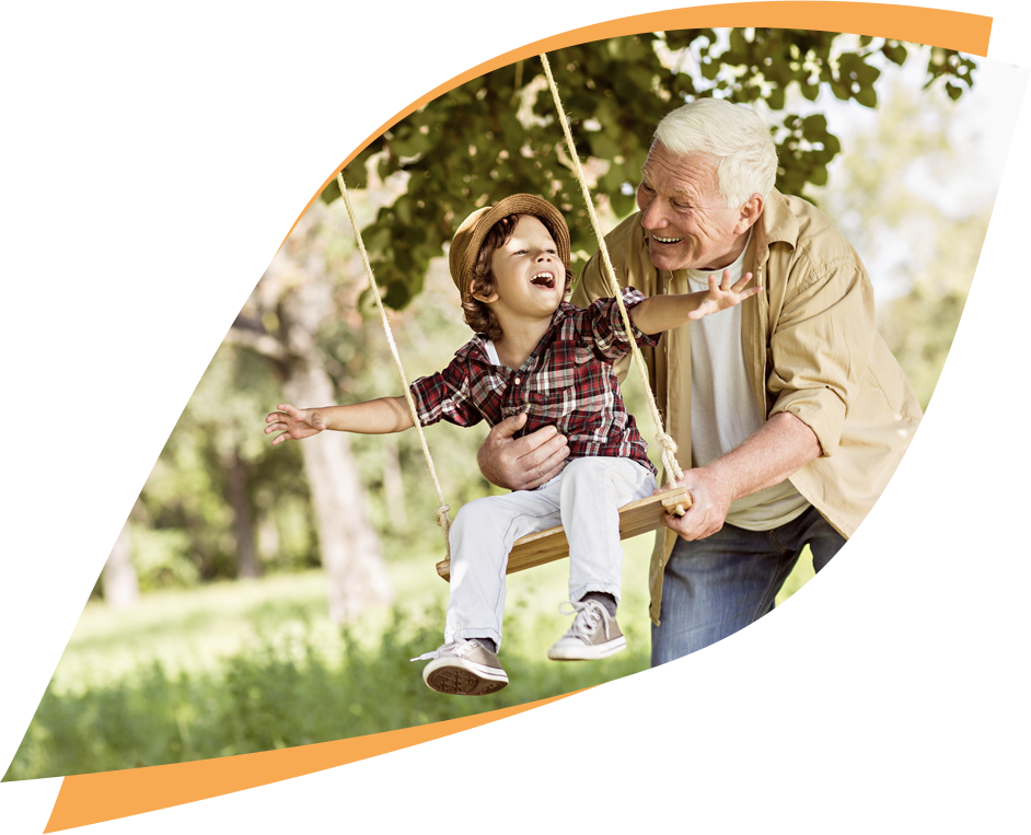 Grandfather pushing boy on swing