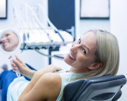 Woman on dental chair smiling