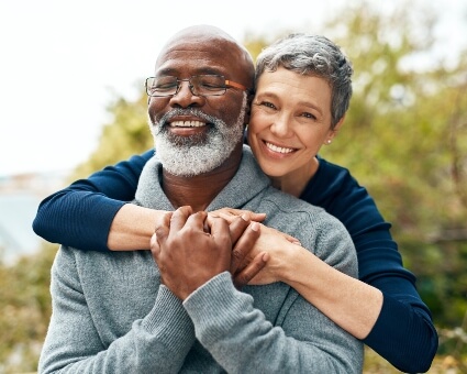 Elderly couple in nature hugging