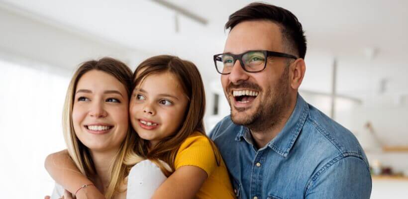 Mom, dad and daughter smiling