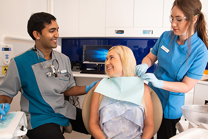 Dr Malesu and hygienist making patient comfortable