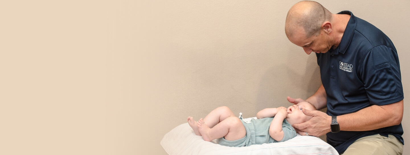 baby looking up at doctor during adjustment