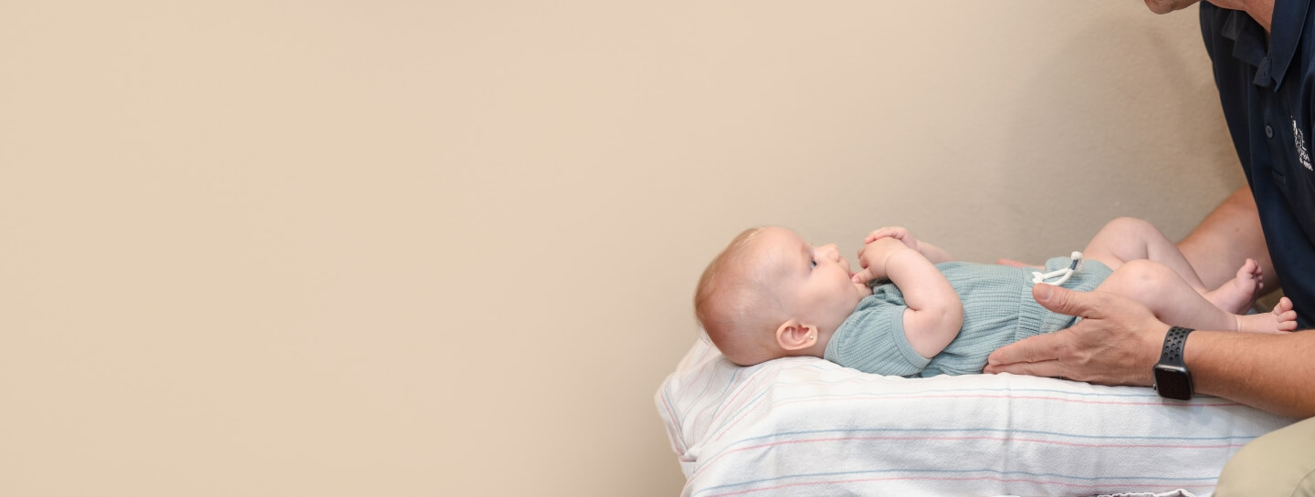 baby looking up at doctor during adjustment