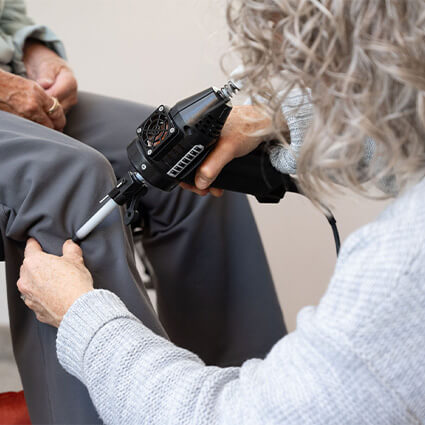 Dr Lisa adjusting patients knee with a tool