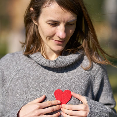 woman-holding paper heart on chest