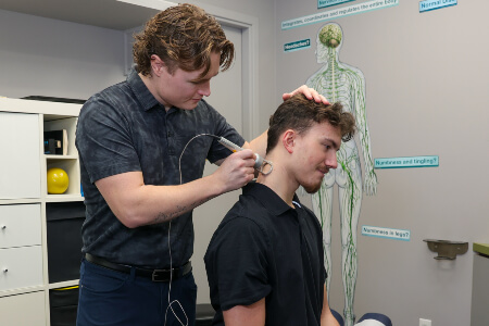 Calgary NW chiropractor using direct current therapy to treat patient