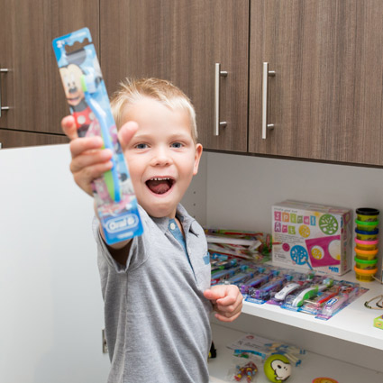 Happy boy with the reward he chose, a toothbrush