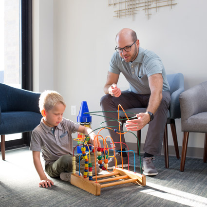 Father and son playing with toys in the waiting room