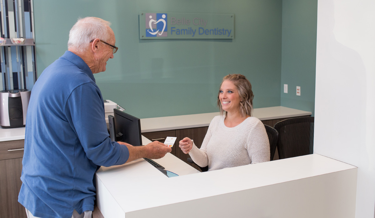 Patient and receptionist smiling at each other