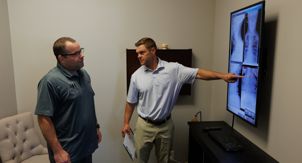 Chiropractor discussing x-ray with patient