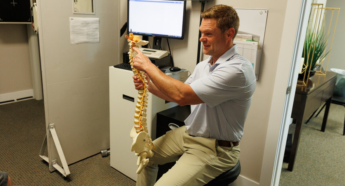 Omaha chiropractor holding spine model