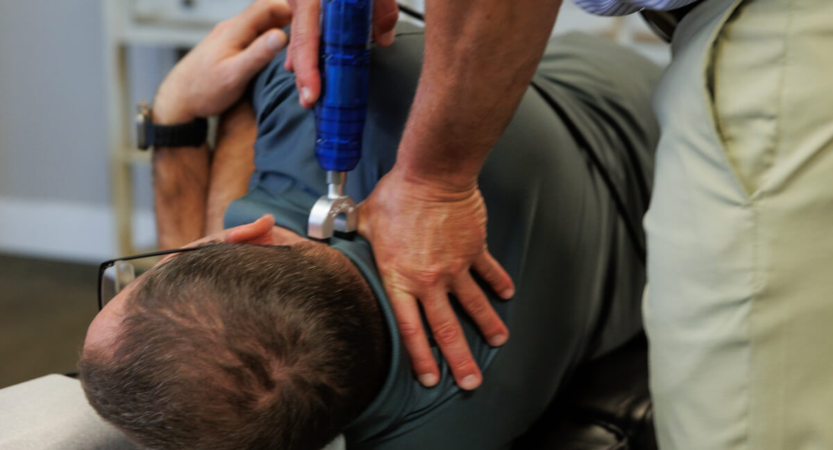Chiropractor using activator technique to treat patients