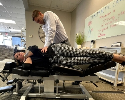 Male chiropractor adjusting female patient
